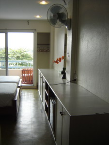 Fridge, wall fan and large cupboard inside River Breeze room.
