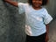 A young smiling girl leaning against a wall in San Miguel