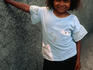 A young smiling girl leaning against a wall in San Miguel