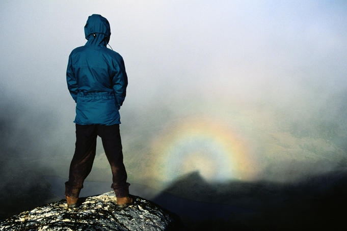 Watching her own shadow on the Dusky Track cast within a circular rainbow, an effect known as Brocken Spectre - Fiordland National Park, Southland