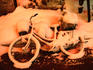 An abandoned bicycle under snow, painted with a red glow from neon in the entertainment quarter in Susukino.