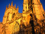 Western face of York Minster, with golden glow from the last rays of the setting sun.