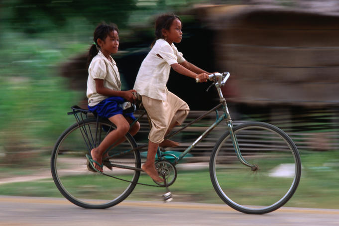 Girls riding bicycle in Bavel village.