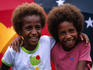 Two young girls from Madang in front of the PNG flag.