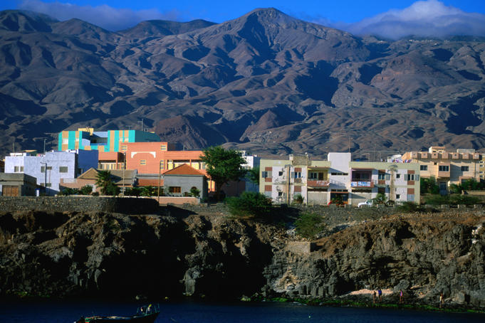 Buildings of town with mountains behind.