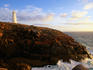 Lighthouse on rocky outcrop.