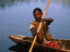 boy rows dugout canoe out, Rwanda