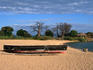 Moored fishing boat and baobab trees on Kaya Mawa Beach, Lake Malawi.