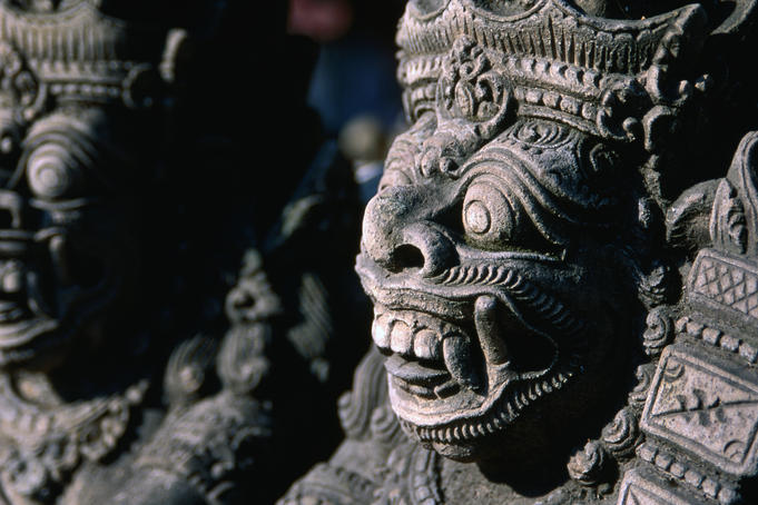 The fierce, defensive face of a Raksas (nocturnal demon) carved in stone in Batubulan.