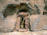 A priest exits through the stone doorway in a rock cliff face; the main entrance to the well-concealed church of Abuna Yemata, near Hawsien
