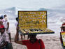 Vendor selling jewellery on beach.