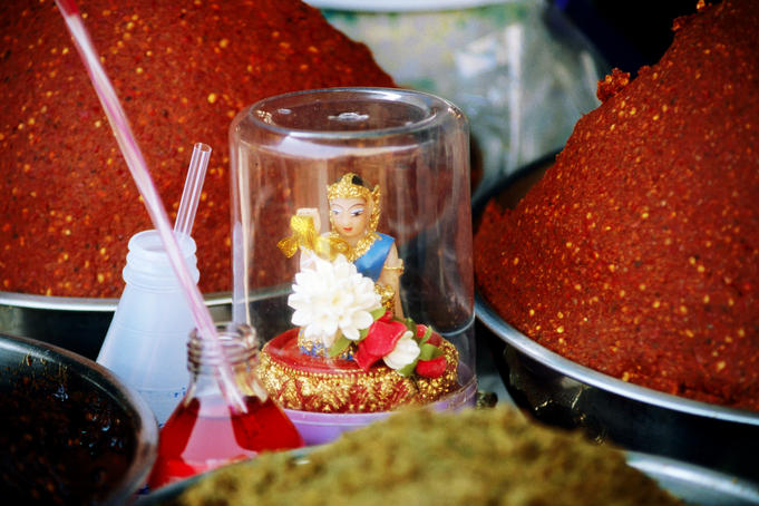 Small figurine amongst red and green curry paste.