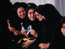 Young women from Tehran, in traditional chador, enjoy a cooling ice-cream and each others company