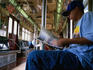 Subway passenger reading the newspaper on the number 6 into Manhattan.