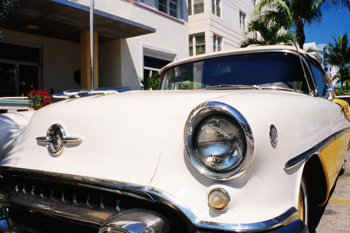A 1957 Oldsmobile yellow convertible in front of the Avalon Hotel.