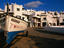 A boat and a row of white-washed houses on the foreshore.