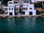 People swimming in front of houses on the waterfront at Alcaufar Cave, a fishing village on the island's south-east coast.