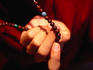 Monk's hands holding prayer beads.