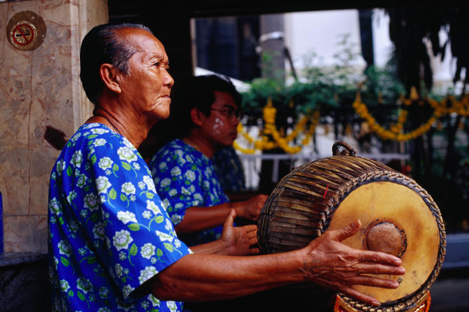 Musician playing drum at Erawan Shrine, Khannayao.