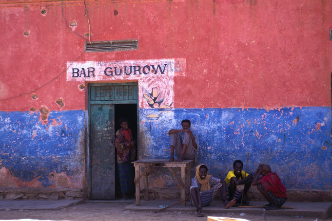 Group of boys sitting outside bar.