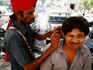 Ear cleaner on a Mumbai street.