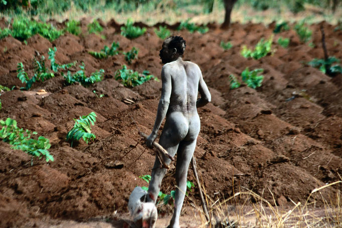 Man with shackled foot in field.