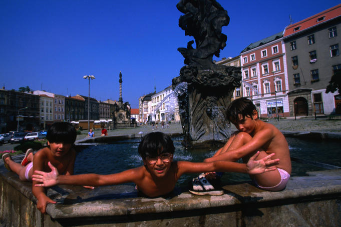 Three boys playing with water in one of the Baroque fountains in the town.