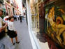 People look at painting of holy image in street during Semana Santa (Holy Week).