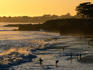 Swimmers on beach at sunset.