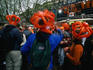 Dancing partygoers wearing oversized crowns on Thorbeckeplein for the Queen's Day celebrations.