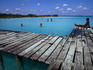 Man lying on a jetty looking at swimmers at the Bacalar Lagoon, Quintanna Roo.