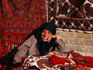 A woman selling hand-woven tablecloths of a traditional design which originates from Kerman.