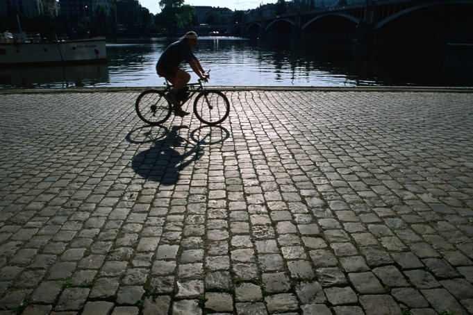 Cycling the cobblestones of the Rasin Embankment along the Vltava River.