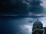 Looking down over the small Greek Orthodox chapel to an approaching ferry in the bay of Santorini.