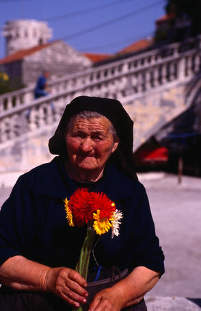 An elderly woman selling flowers in Korcula.