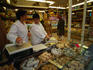 Shopkeepers inside cheese shop (fromagerie) in Rue St Antoine, Le Marais suburb.