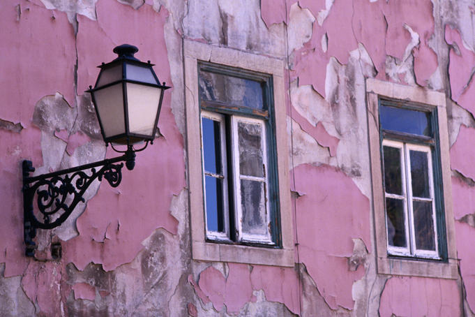 Pink paint peeling on exterior of old building in Alfama.