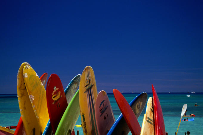 Formation of surfboards on beach with ocean in background.
