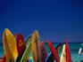 Formation of surfboards on beach with ocean in background.