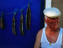 Fisherman (mestre do mar) sitting near curing fillets.