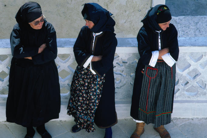Three women in traditional dress at the Festival of Assumption of Mary.