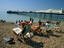 Sunbathers on deckchairs near Brighton pier.