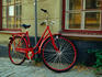 Red bicycle against old house.