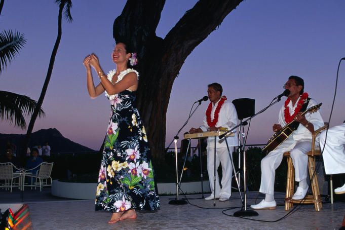 A hula dancer, with the Hawaiian trio The Islanders, at the Halekulani Waikiki.