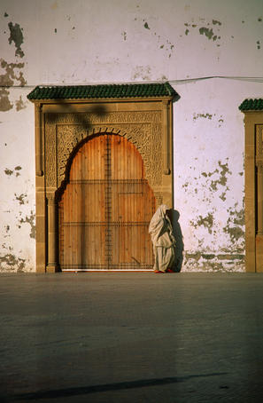 Muslim woman standing in a doorway.