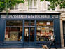 Man walking dog outside Tapisseries de la Boucherie needlework shop.