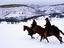 Cowboys galloping through snow, USA