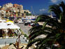 Sidewalk restaurants, anchor and palm alongside yacht hrabour.