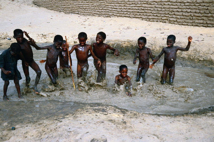 Boys playing in a mud puddle, Timbuktu, Mali.