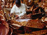 Craft for sale: A woman producing wooden souvenirs at Bruma Market World